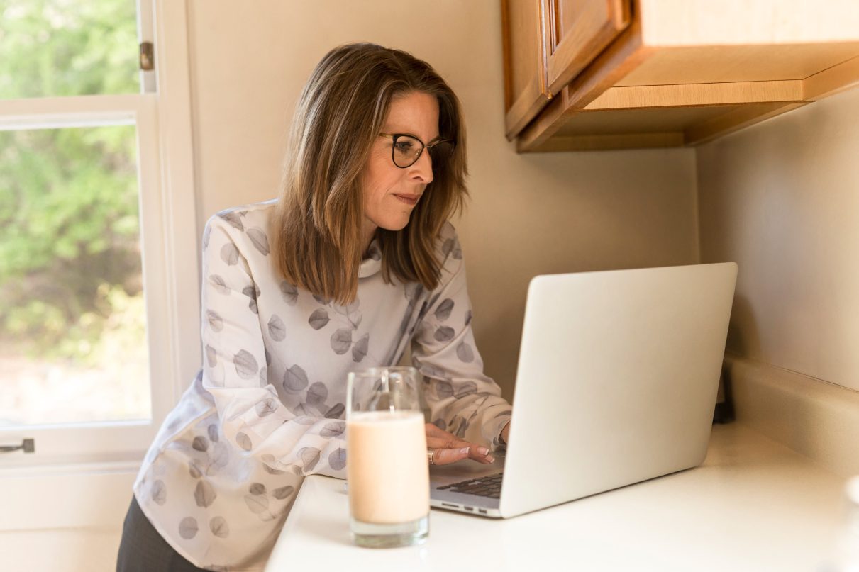 woman working on a laptop at the kitchen counter