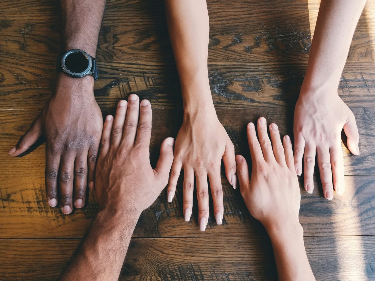 hands across the table demonstrating multi-culturalism.