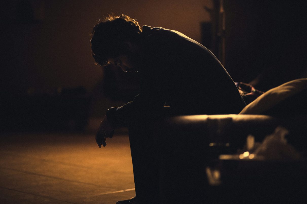 person sat in the dark looking hopeless and depressed